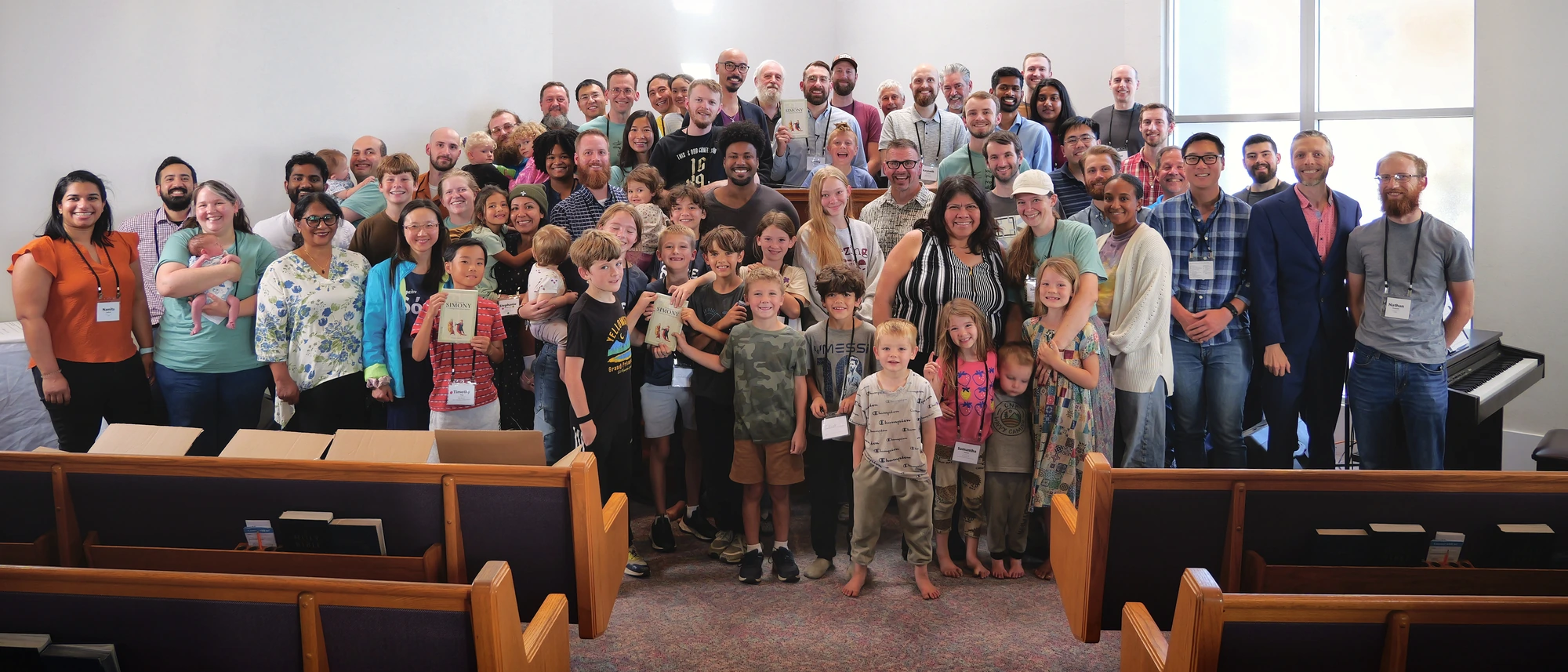 Conference attendees and their children gathered in the sanctuary, some holding copies of The Doctrine of Simony